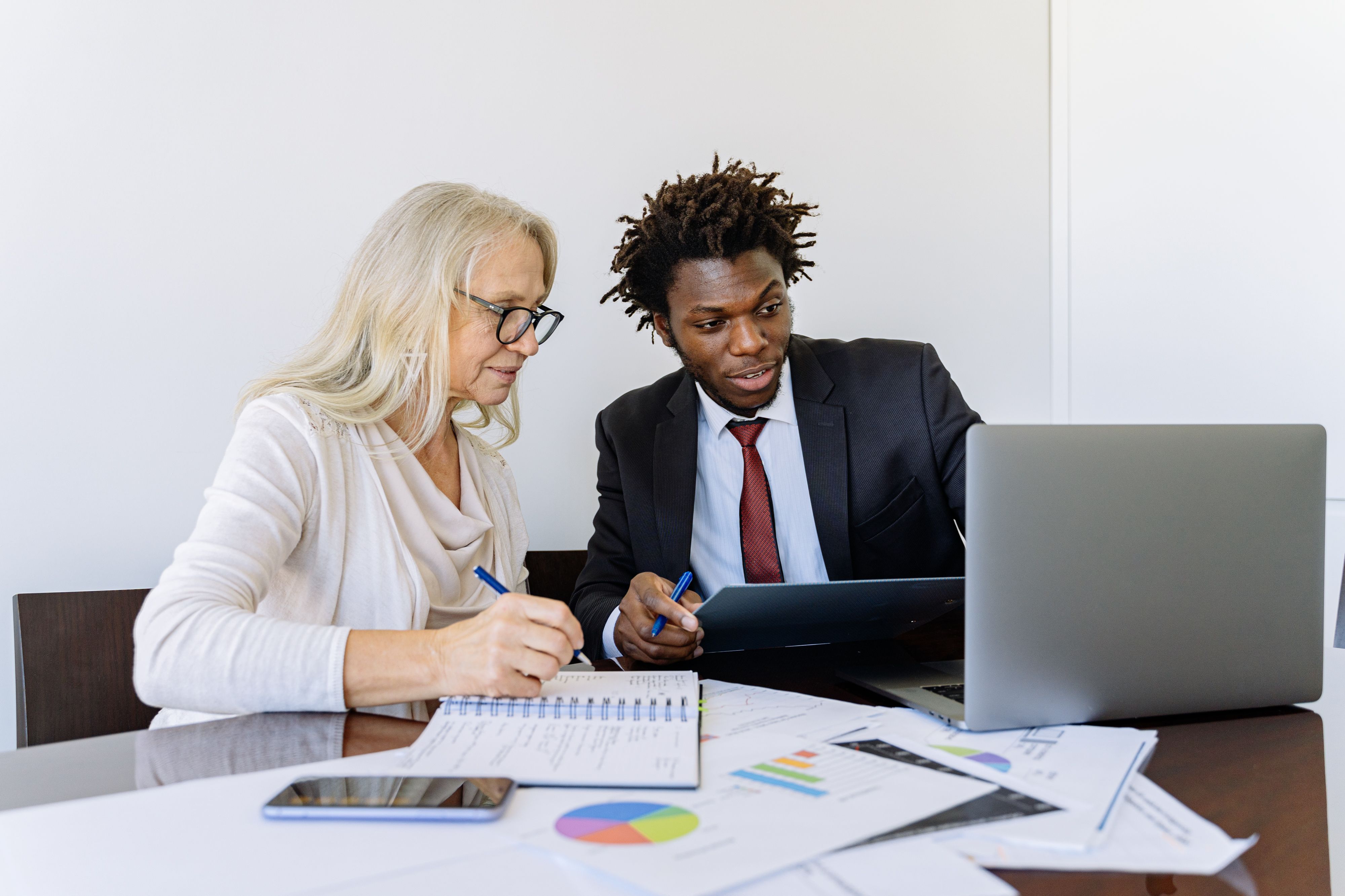 Two Property Managers Discuss Marketing Strategy at a Desk